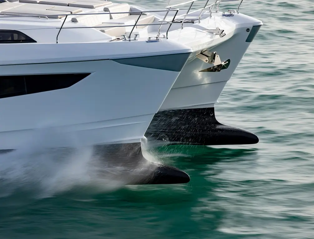 Two sleek motorboat hulls emerge from the water, creating splashes against a turquoise background.